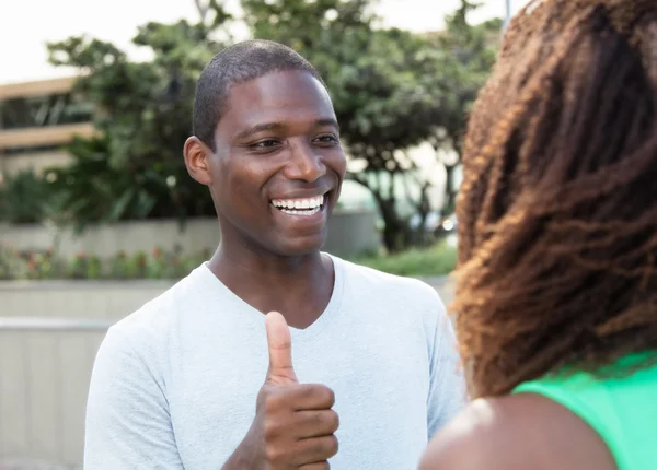 Lachender Afrikaner zeigt seiner Freundin Daumen — Stockfoto