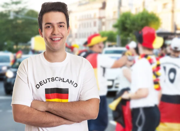 Lachender deutscher Fan mit dunklen Haaren mit anderen Fans — Stockfoto