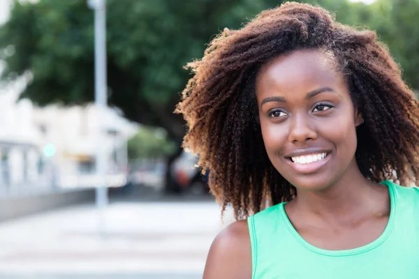 Wunderbare afrikanisch-amerikanische Frau im grünen Hemd im Freien — Stockfoto