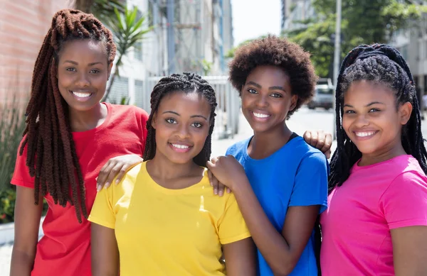 Vier lachende afrikanisch-amerikanische Freundinnen in der Stadt — Stockfoto