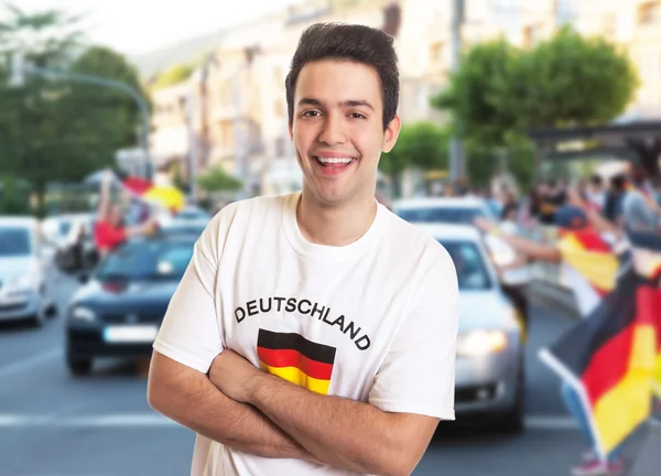 Glücklicher Fan im Deutschland-Trikot mit anderen Fans — Stockfoto