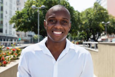 Mutlu Afrika kökenli Amerikalı adam açık beyaz gömlekli