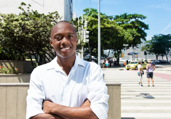 Africano americano homem em camisa branca com braços cruzados ao ar livre — Fotografia de Stock