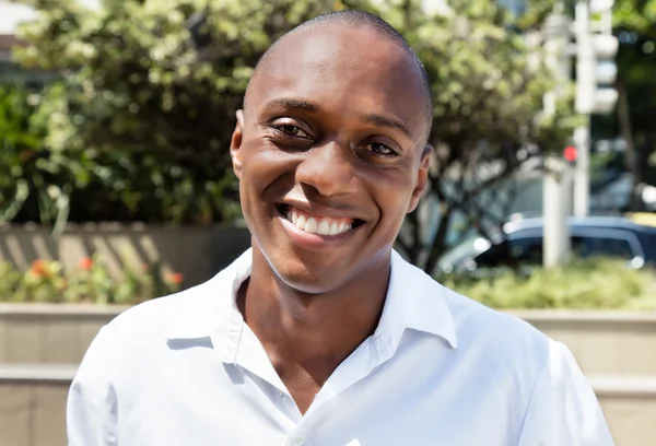 Afrika kökenli Amerikalı adam beyaz gömleği giyince açık gülüyor — Stok fotoğraf