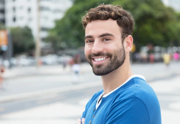 Glücklich lachender Typ mit Bart und blauem Hemd in der Stadt — Stockfoto