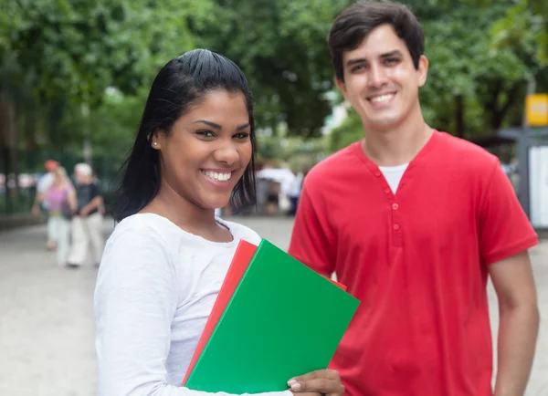 Skrattande latin kvinnlig student med kaukasiska vän utomhus — Stockfoto