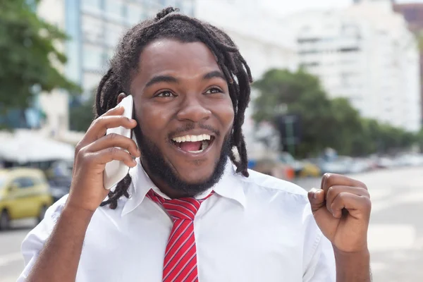Счастливый африканский американский бизнесмен с дредами на телефоне — стоковое фото