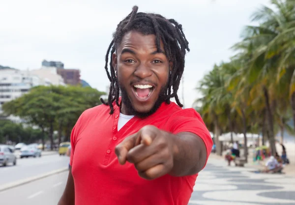 Pointing african american guy with dreadlocks in city — Stock Photo, Image