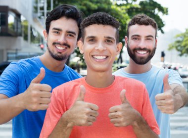 Gösterilen üç Latince ve beyaz arkadaş yukarı başparmak