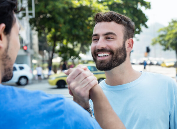 Рукопожатие двух друзей в городе
