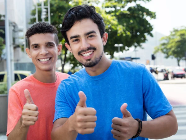 Two hispanic guys showing thumbs in city — Stock Photo, Image