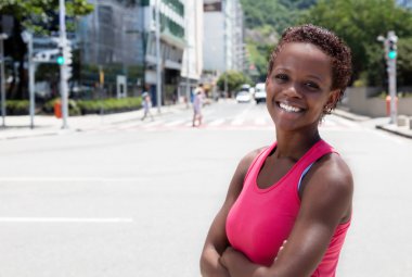 Afro-Amerikan kız şehirde Pembe gömlekli gülüyor