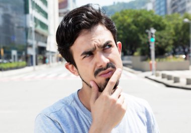 Şehirde bir gri gömlekli düşünceli İspanyol adam