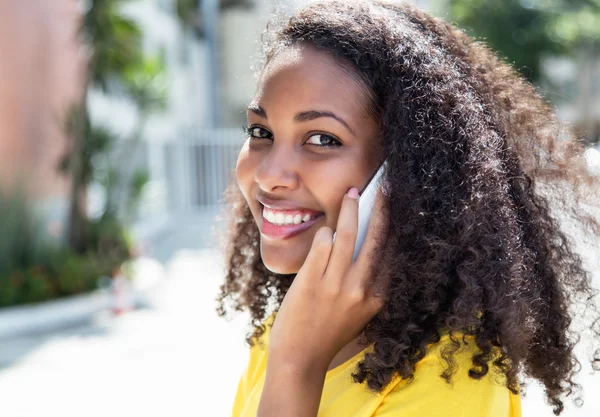 Mosolygó latin nő göndör haj a telefon nyáron — Stock Fotó