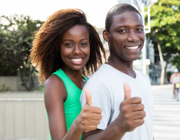 Schönes afrikanisch-amerikanisches Paar zeigt Daumen in der Stadt — Stockfoto