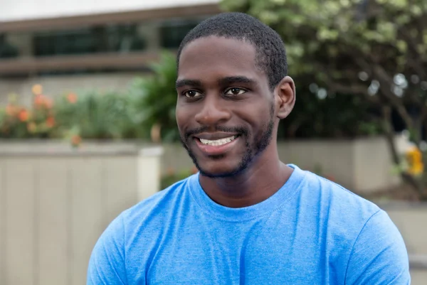 Hombre afroamericano con camisa azul mirando hacia los lados — Foto de Stock