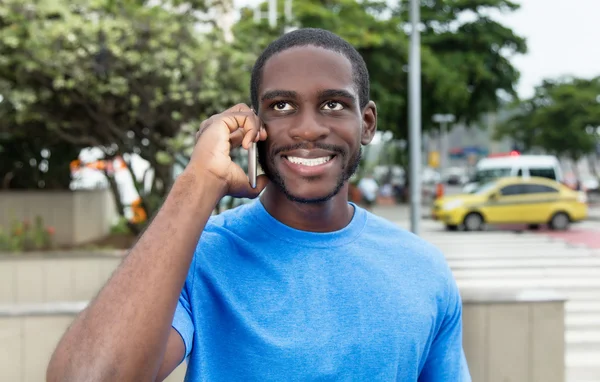 Africano americano com camisa azul no telefone — Fotografia de Stock