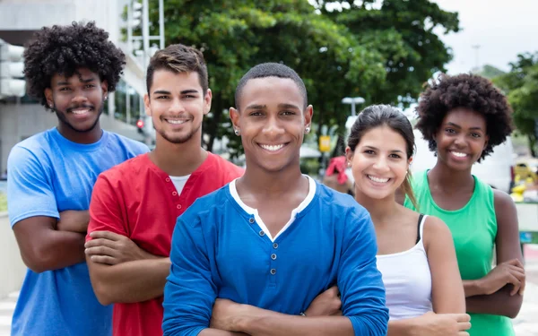 Groep internationale jonge volwassenen lachen om de camera in de stad — Stockfoto