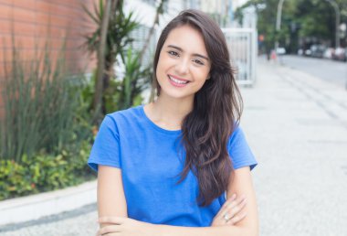 Şehirde mavi gömlekli gülen beyaz kadın