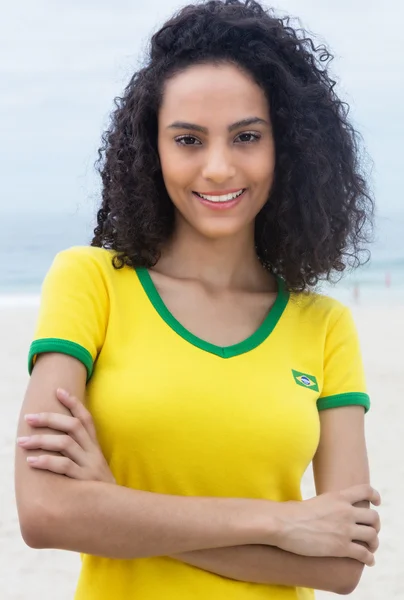 Abanico deportivo brasileño de pie con pelo rizado y brazos cruzados — Foto de Stock