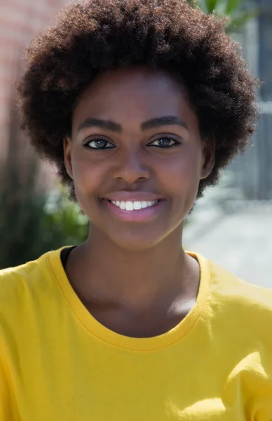 Retrato de uma típica mulher afro-americana com uma camisa amarela — Fotografia de Stock