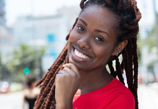 Glückliche afrikanische Frau mit Dreadlocks in der Stadt — Stockfoto