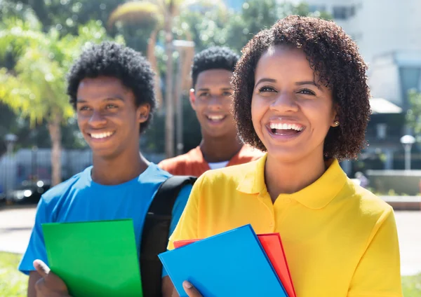 Lachende lateinamerikanische Studentin mit Freunden — Stockfoto