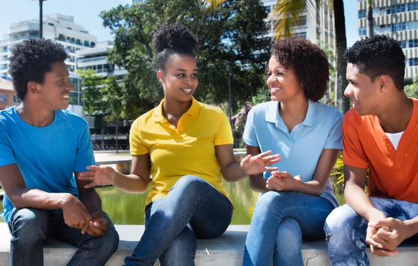 Grupo de cuatro adultos jóvenes latinoamericanos que hablan al aire libre —  Fotos de Stock