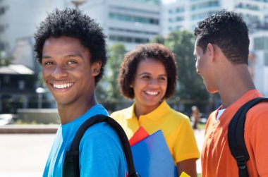 Latin Amerikalı erkek öğrenci arkadaşlarla gülüyor