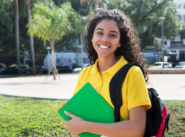 Skrattande latinamerikanska kvinnlig student med långa mörka hår — Stockfoto