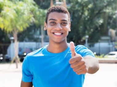 Mavi gömlek gösteren başparmak ile Latin Amerika adam