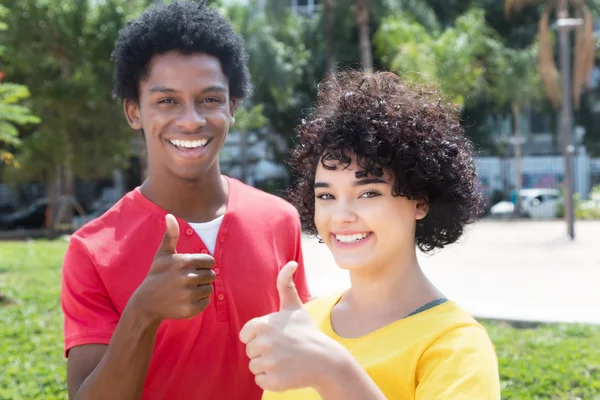 Kaukasiska flicka med afrikanska amerikanska pojkvän visar tummen — Stockfoto