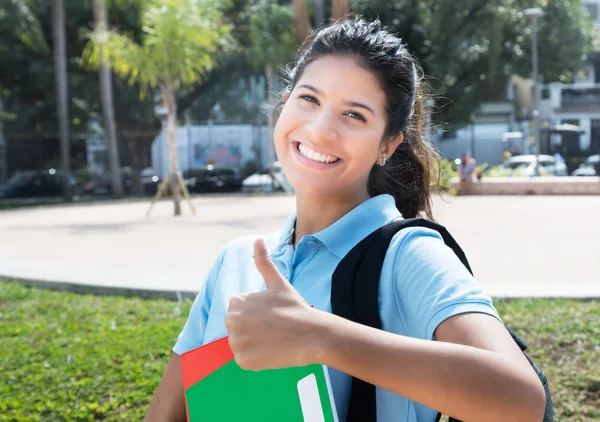 Mooie Kaukasische vrouwelijke student duim in de stad in tonen — Stockfoto