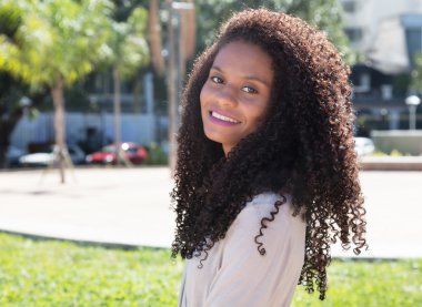 Uzun kıvırcık saçlı mutlu latin kadın