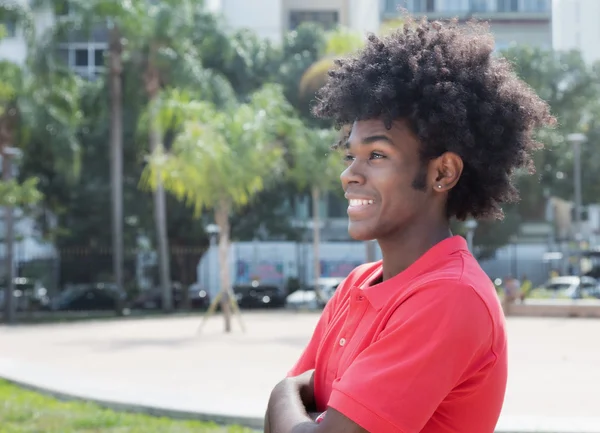 Afrikaanse jongvolwassene met typische afro kapsel zijwaarts op zoek — Stockfoto