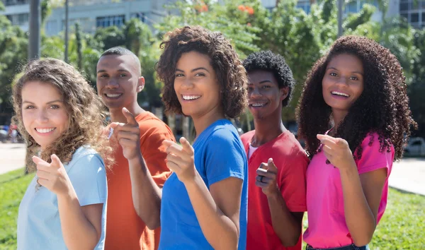 Groep lachen Braziliaanse jongvolwassenen wijzend op camera — Stockfoto