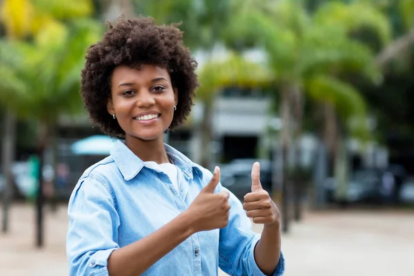 ブラジル出身の黒人女性が夏に街で親指を立てて — ストック写真