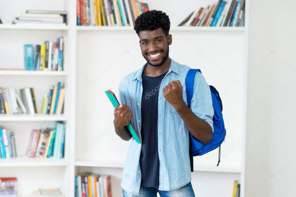 Successful young african american male student with beard at library of university