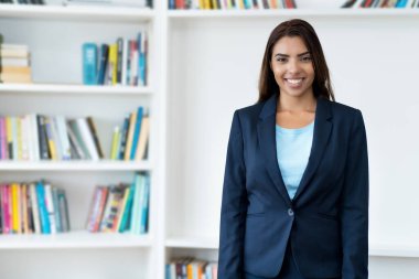Şirketin ofisinde gülen Meksikalı iş kadını stajyer.