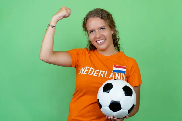 用绿色背景的橙色球衣为来自荷兰的女足球迷欢呼 — 图库照片