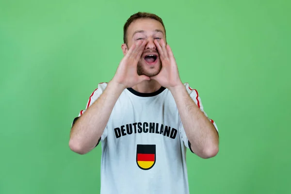 Wrzeszczący Fan Piłki Nożnej Niemiec Koszulką Piłkarską Zielonym Tle — Zdjęcie stockowe