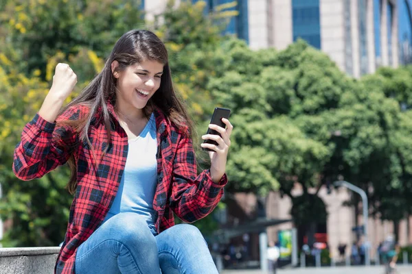 応援スペインの若い大人の女性受信メッセージで良いニュースで電話で屋外で夏に市 — ストック写真