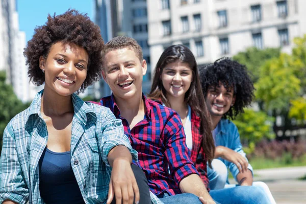 African american woman with group of multicultural young adults in a row outdoor in city in summer