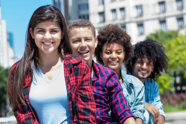 Spanish teen with group of multicultural young adults in a row outdoor in city in summer