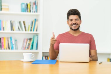 Evde bilgisayar başında sakallı, yakışıklı, olgun bir adam.