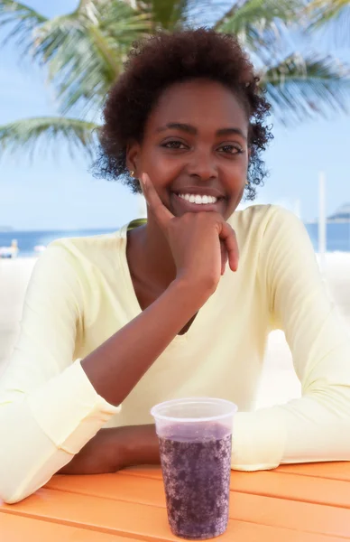 Laughing brazilian woman at beach with soda — Stok fotoğraf