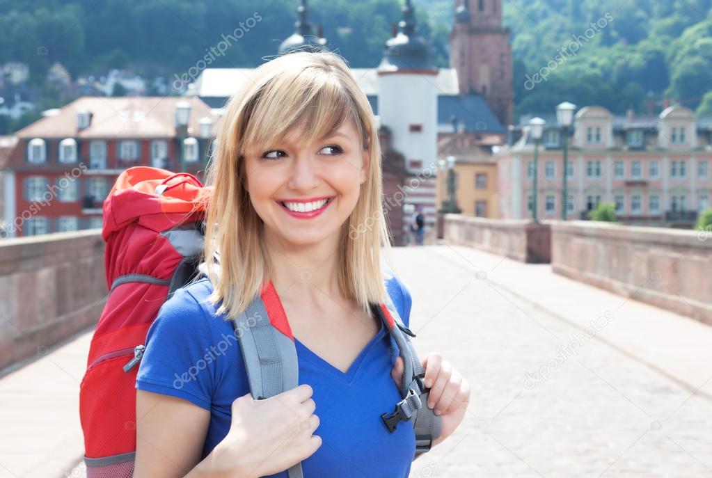 Happy backpacker with blonde hair in Europe