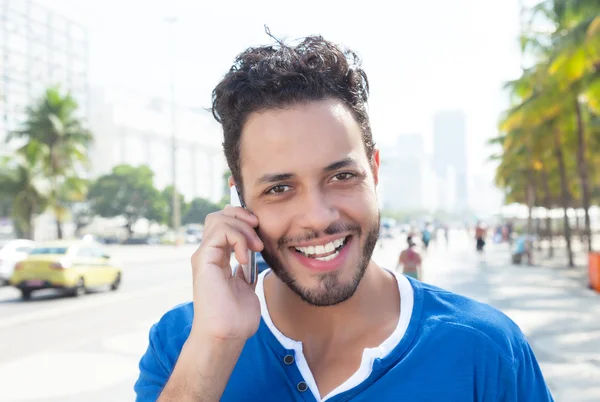 Handsome brazilian man at phone at city — Stock Photo, Image