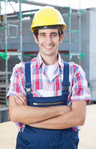 Hispanic construction worker at building site with crossed arms — Stock Photo, Image