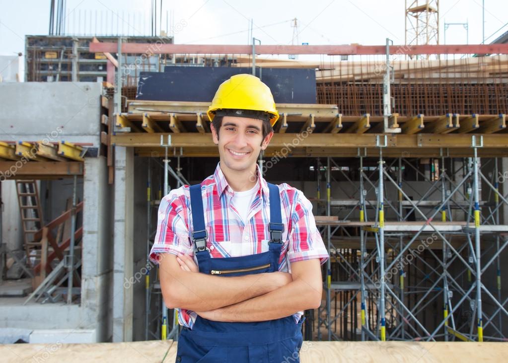 Happy hispanic construction worker at building site